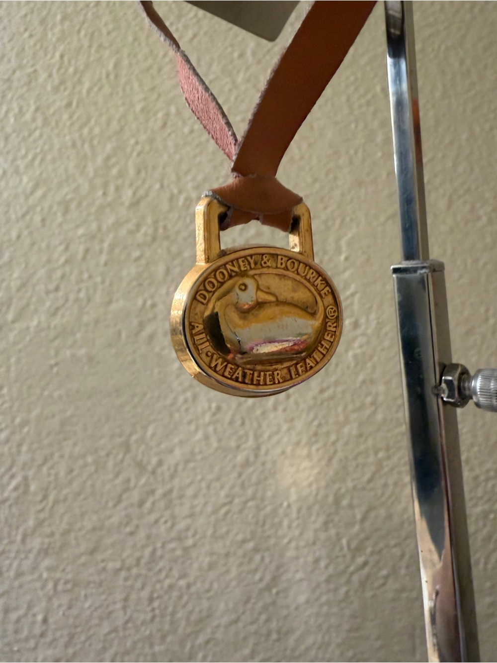 Dooney & Bourke Gold Medallion Charm on Tan Leather hang tag